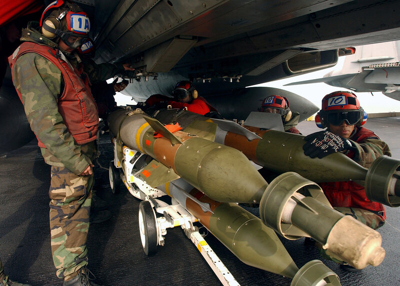 Military personnel loading missiles
