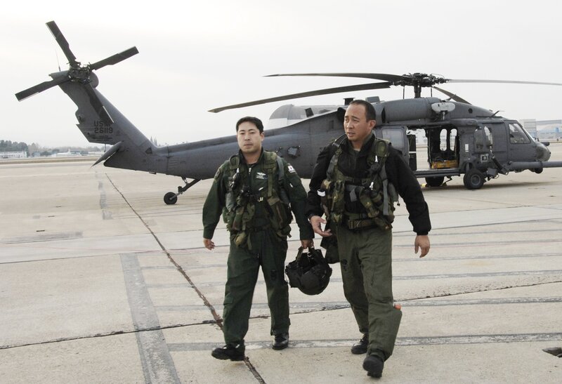 Military personnel near helicopter