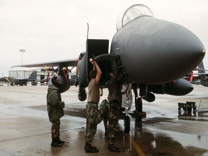 Military personnel servicing fighter jet