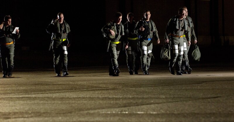 Military personnel walking at night