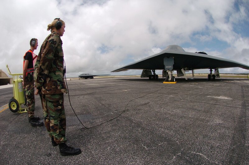 Military personnel with stealth bomber
