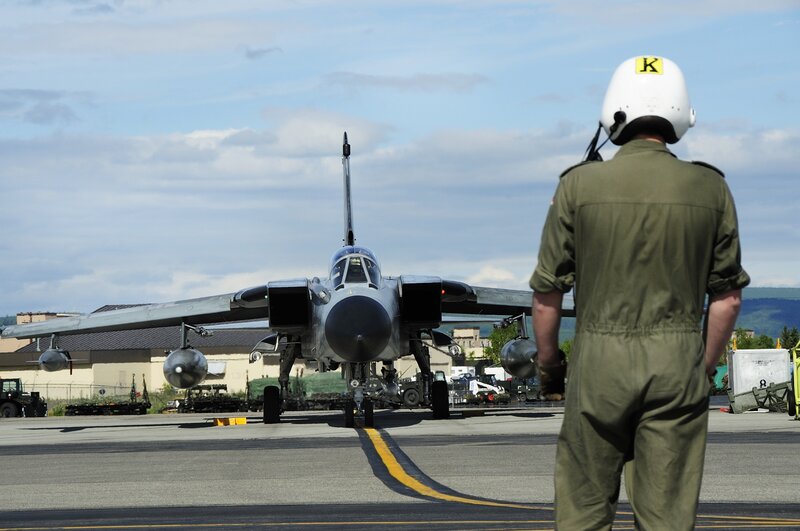 Military pilot and jet on tarmac