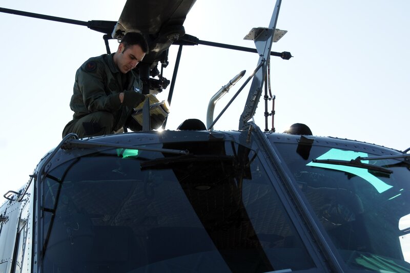 Military pilot inspecting helicopter