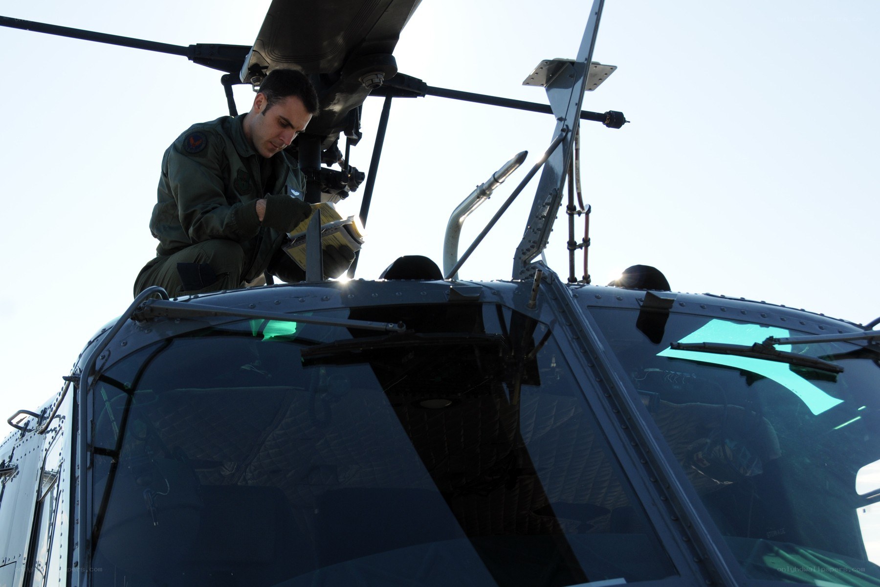 Military pilot inspecting helicopter