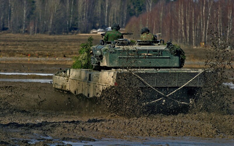 Military tank in muddy field