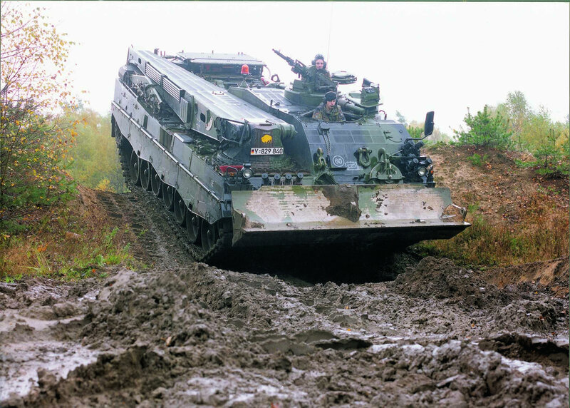 Military tank in muddy terrain