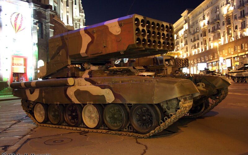 Military tank on city street at night