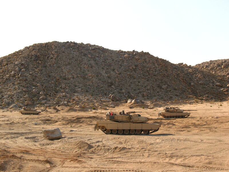 Military tanks in desert terrain