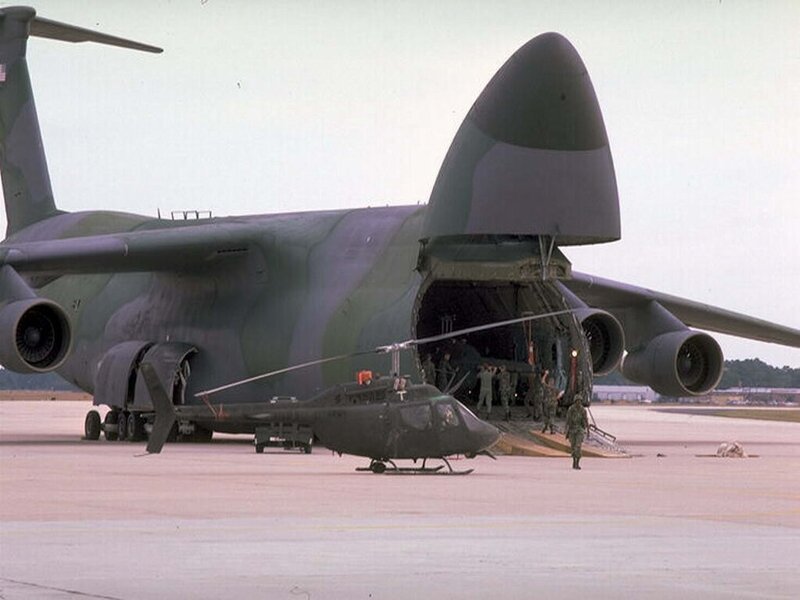 Military transport aircraft loading helicopter