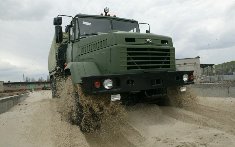 Military truck driving through sand
