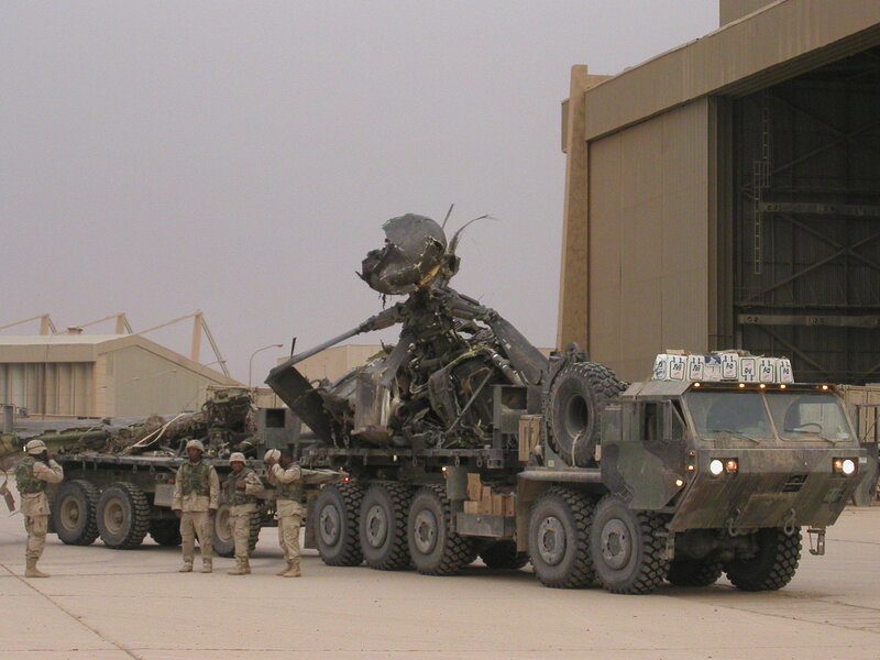Military vehicle carrying wreckage