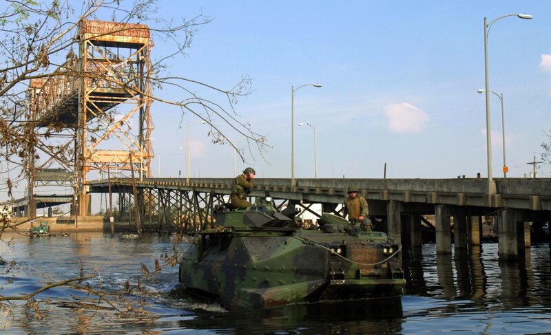 Military vehicle crossing flooded bridge