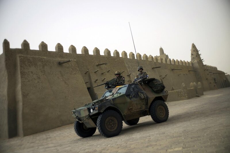 Military vehicle near ancient wall