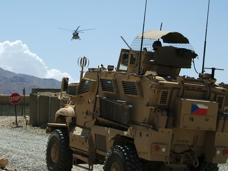 Military vehicle with helicopter in background