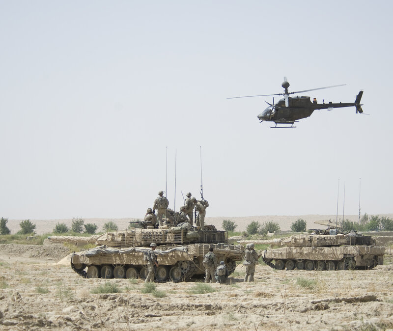 Military vehicles and helicopter in desert