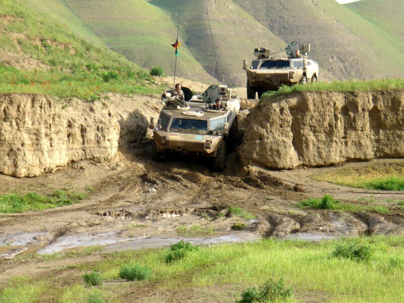 Military vehicles crossing a ditch