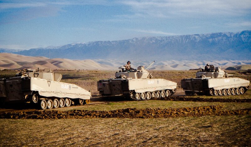 Military vehicles in desert terrain