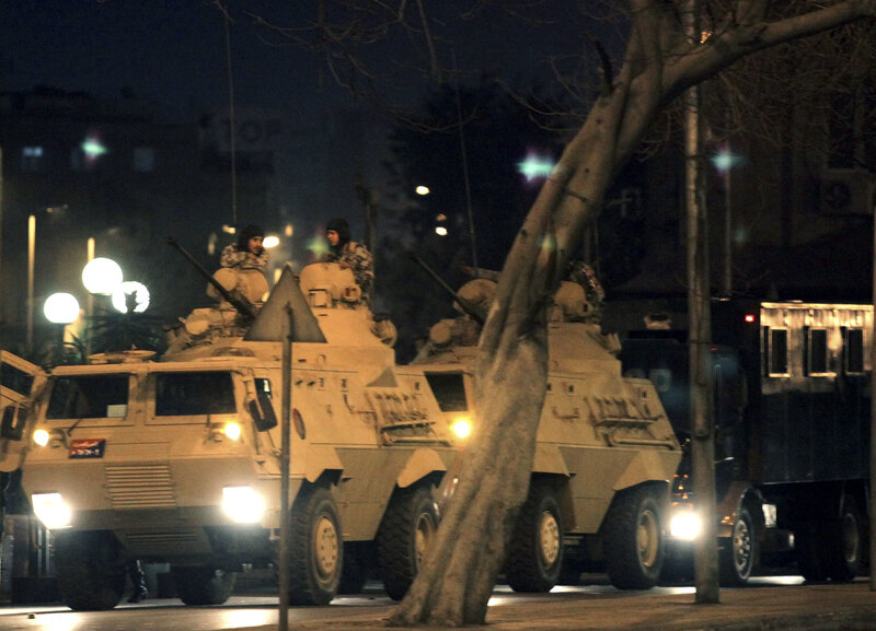 Military vehicles on city street at night