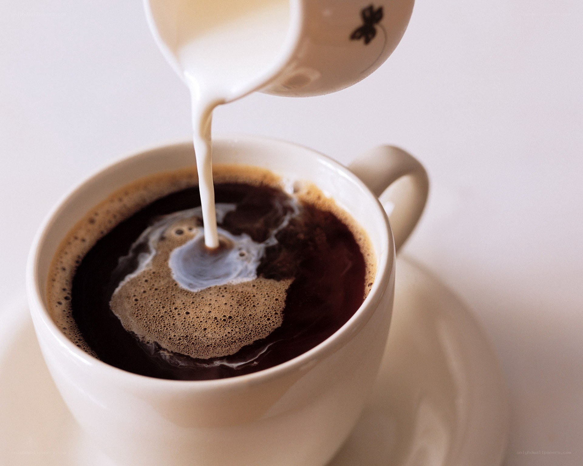 milk being poured into coffee