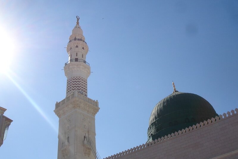 Minaret and green dome under blue sky