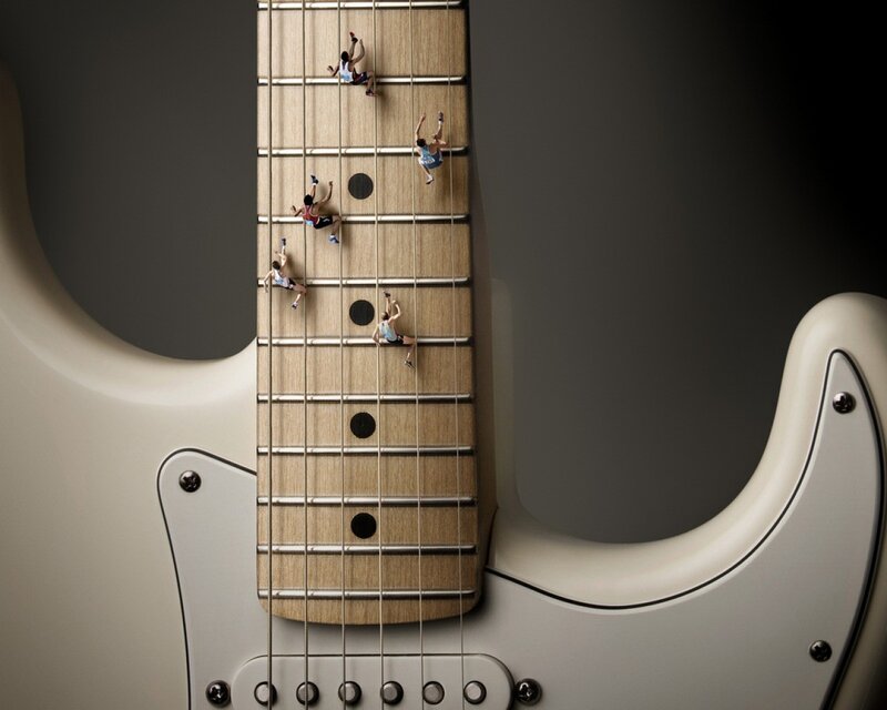 Miniature climbers on guitar neck