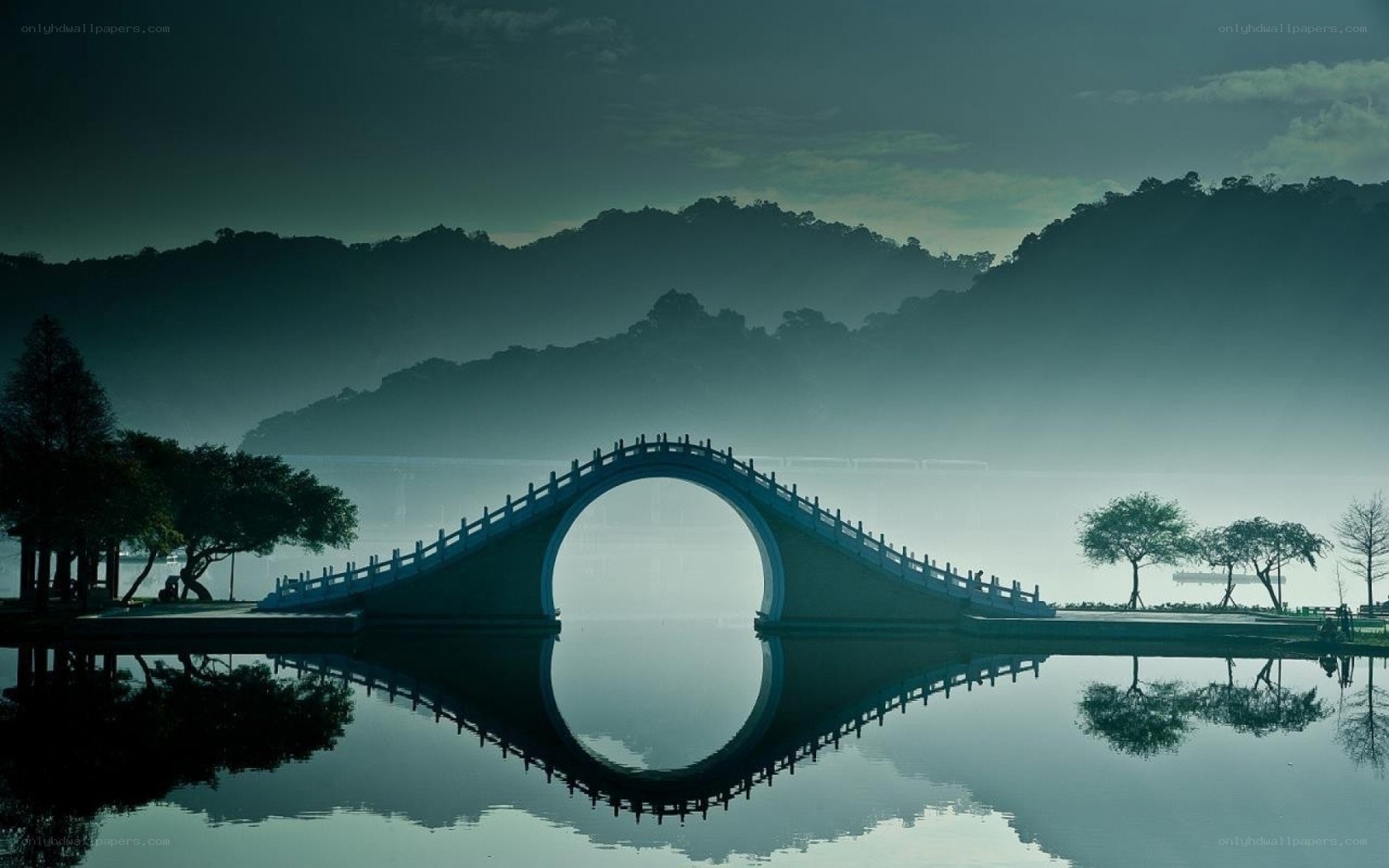 Misty bridge over calm water