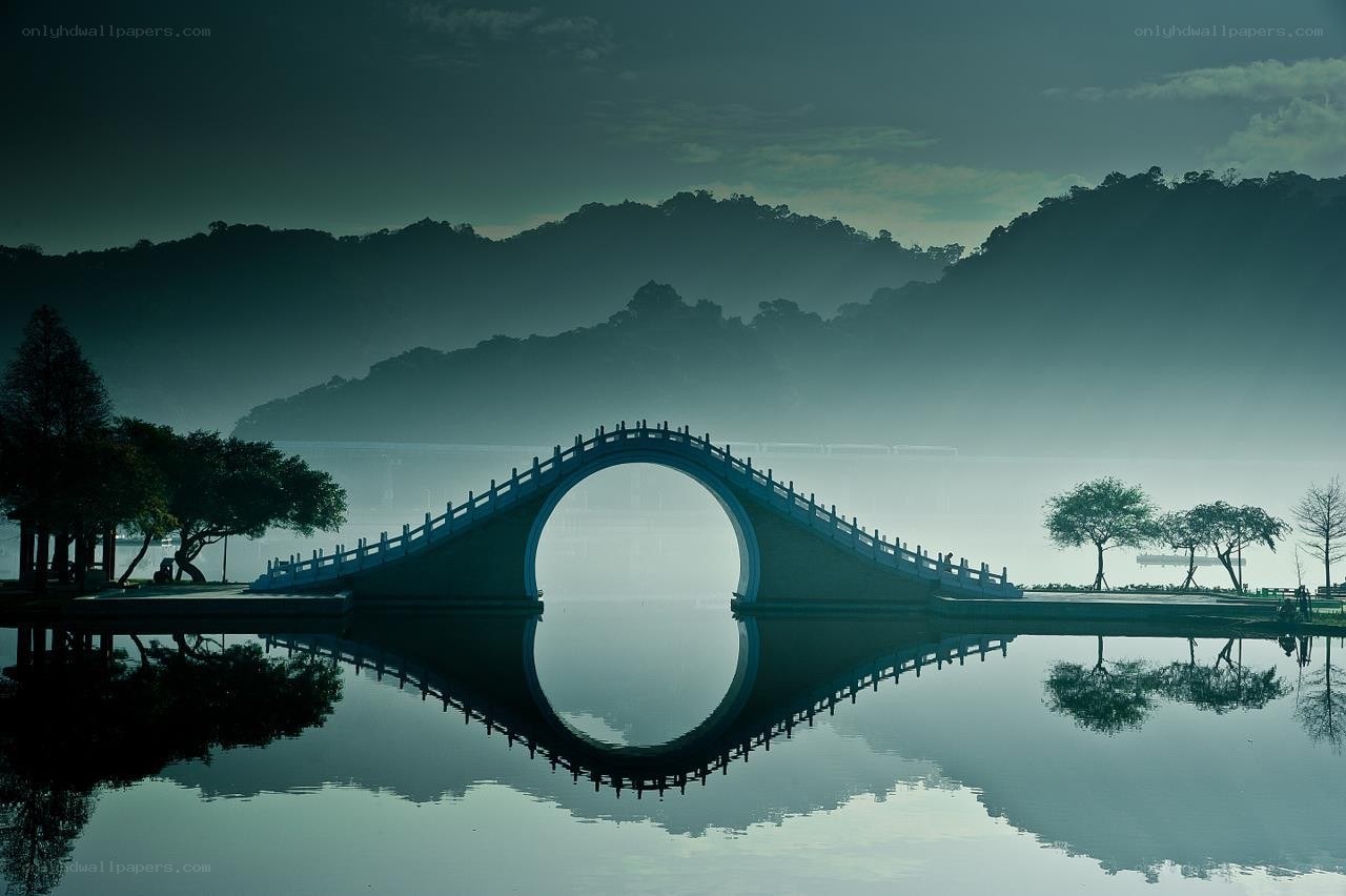Misty bridge over calm water