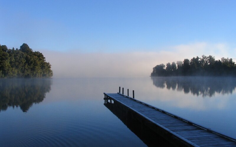 Misty lake at dawn with dock