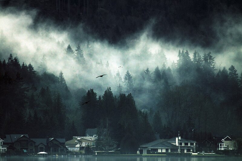 Misty lake houses at dawn