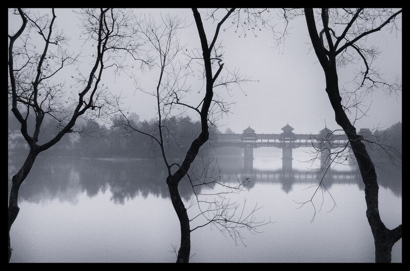 Misty lake with covered bridge