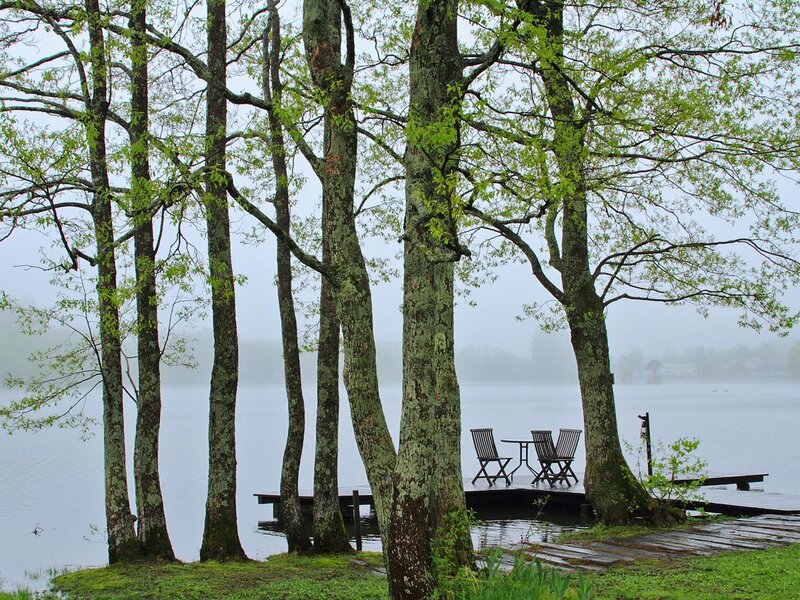 Misty lake with dock and chairs
