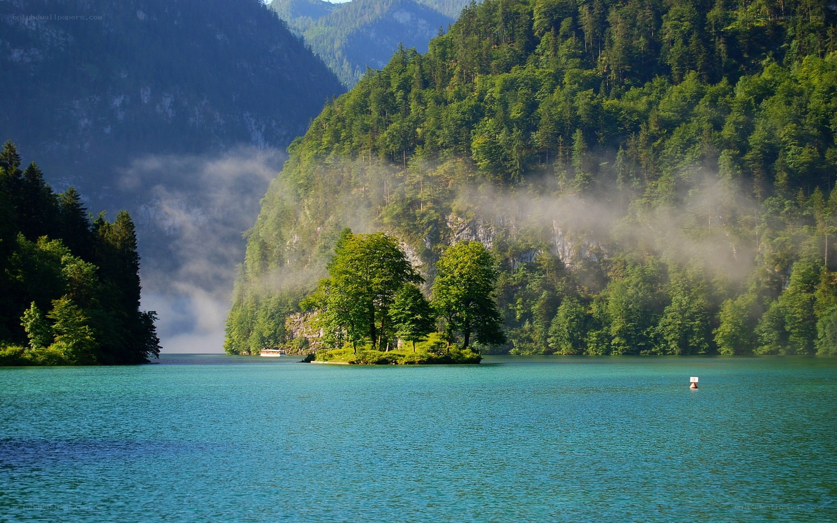 Misty lake with forested mountains