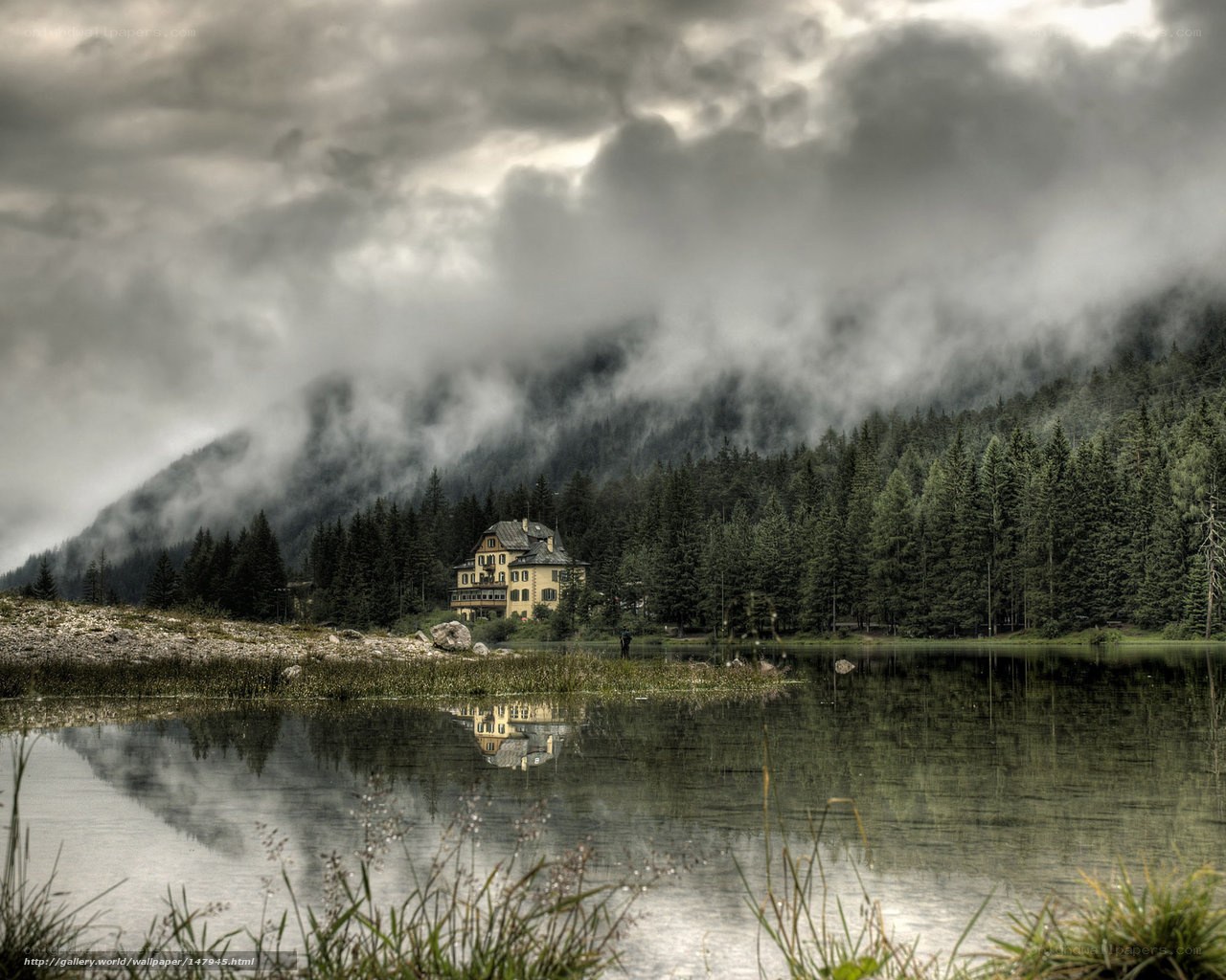 Misty lake with mountain lodge