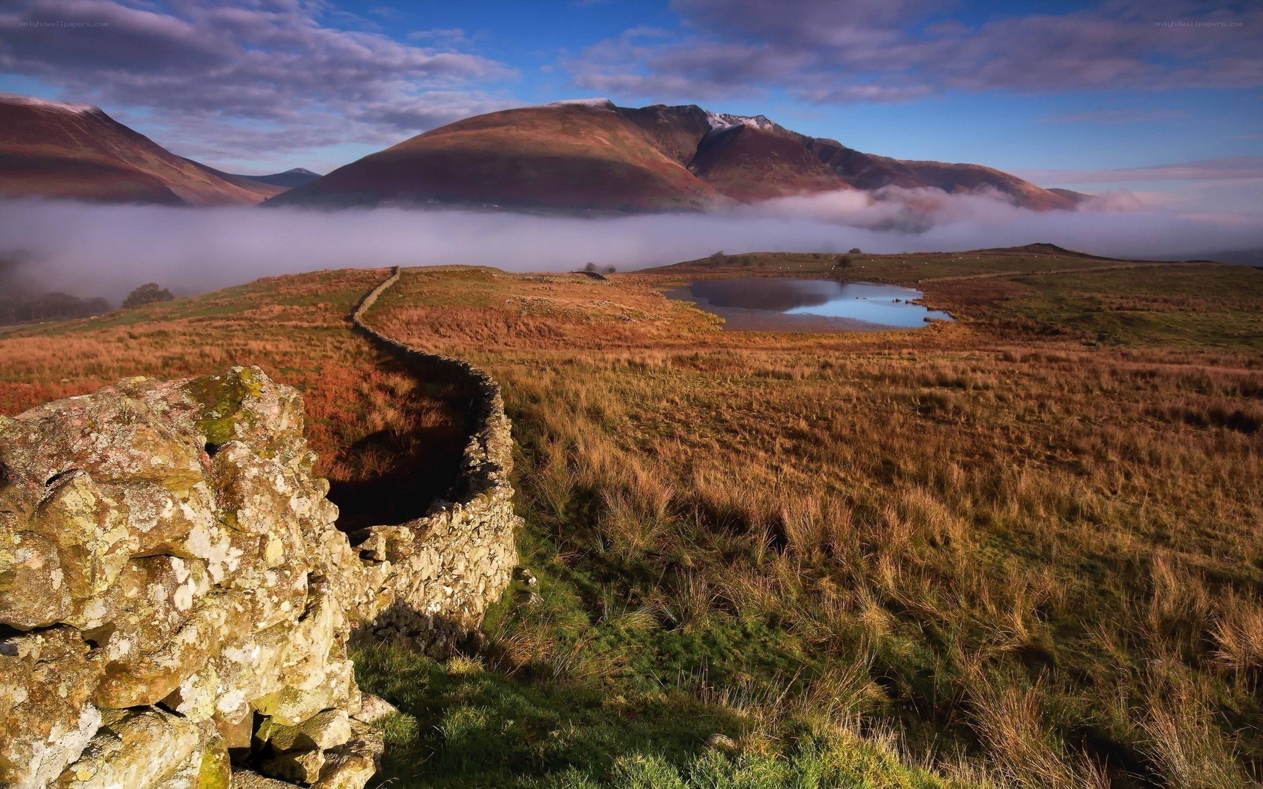 Misty mountain landscape with stone wall