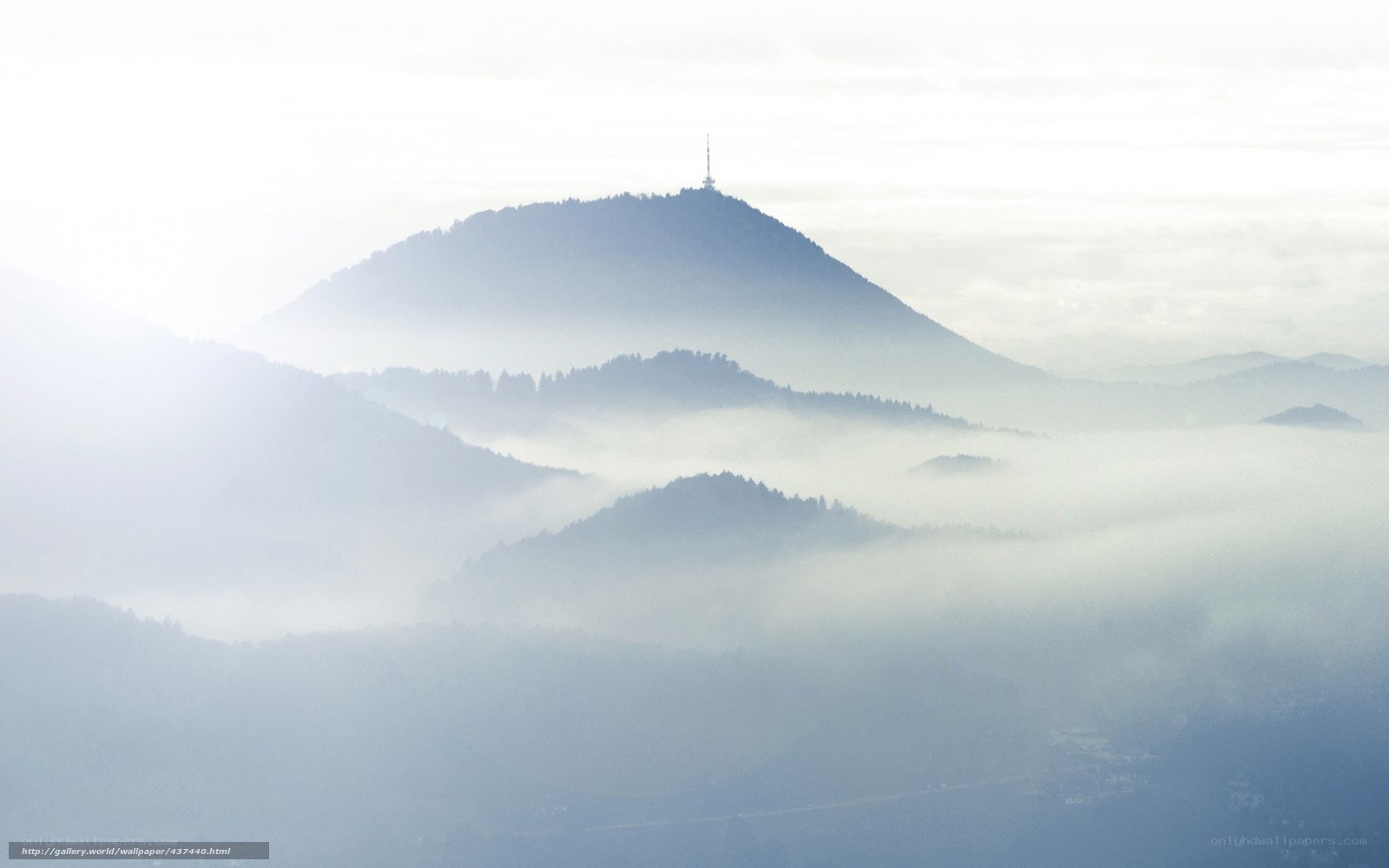 Misty mountain peaks with tower