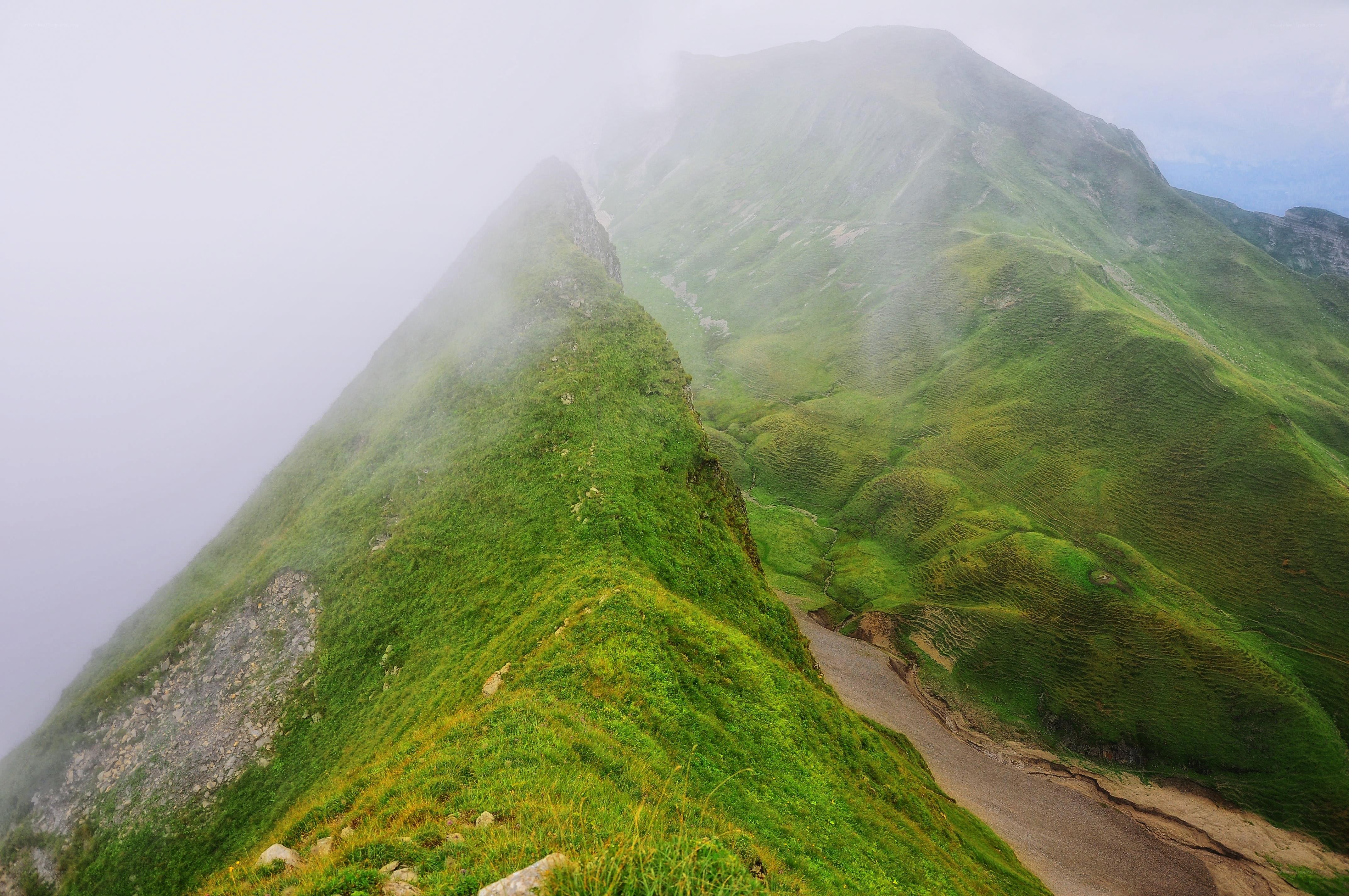 Misty mountain ridge with green slopes