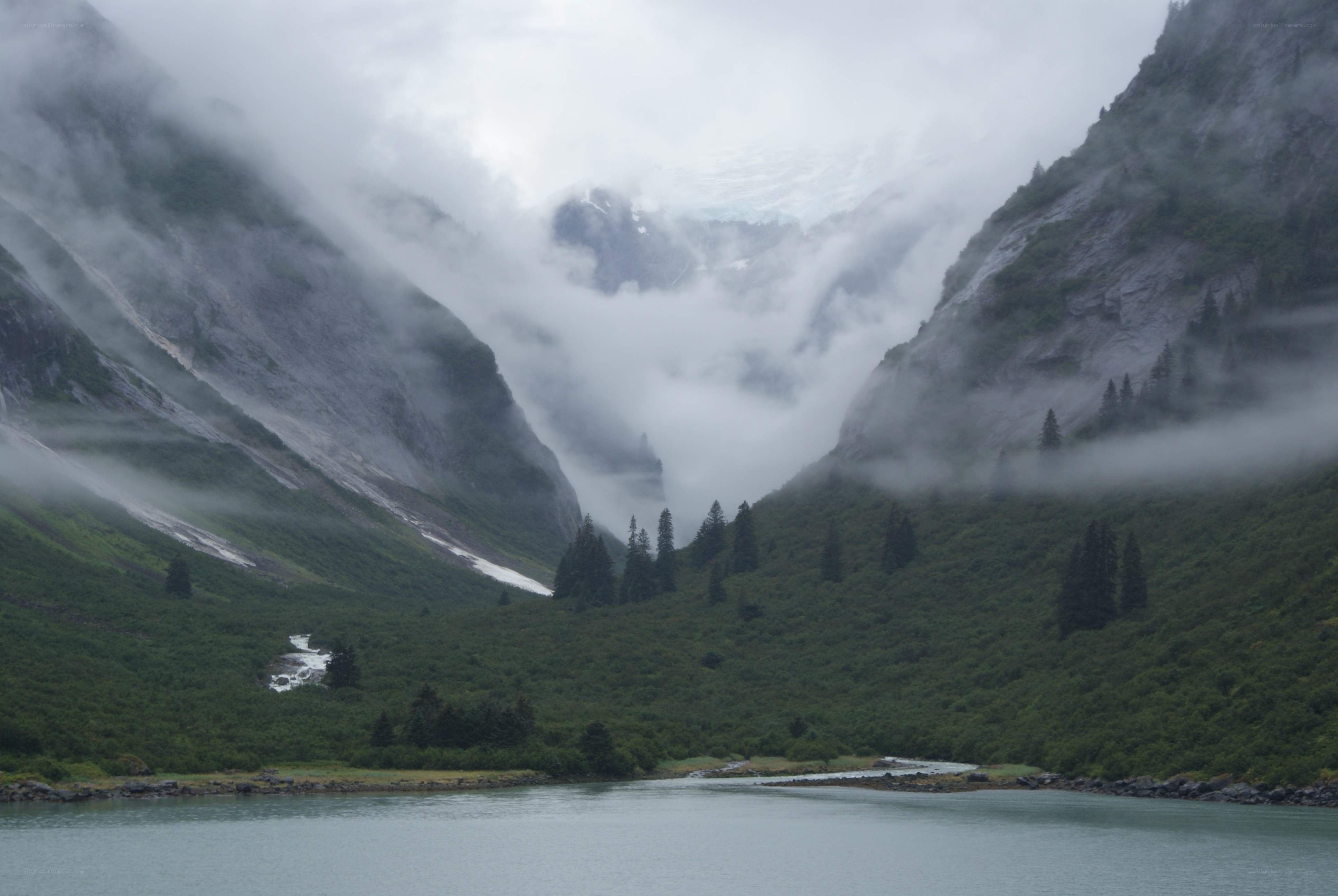 Misty mountain valley with lake