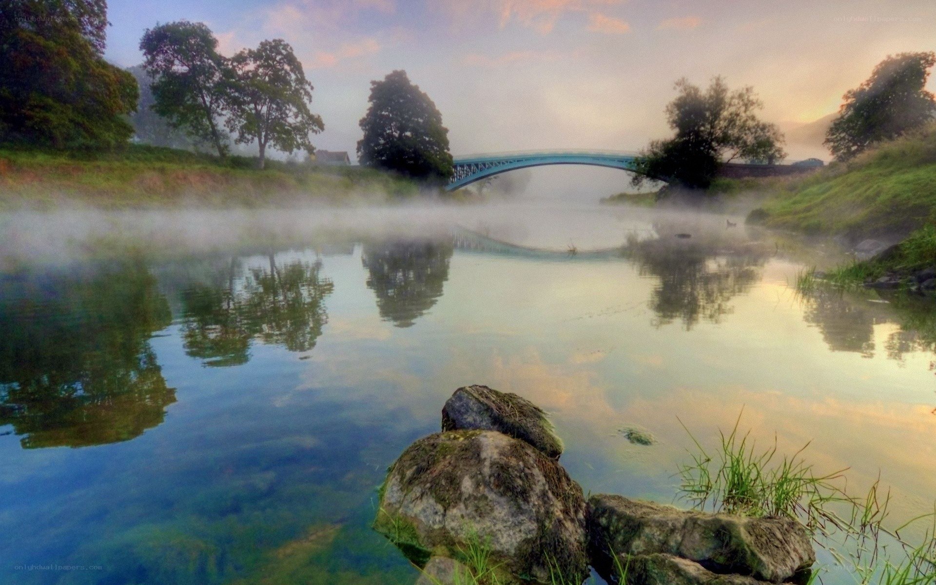 Misty river at dawn with bridge