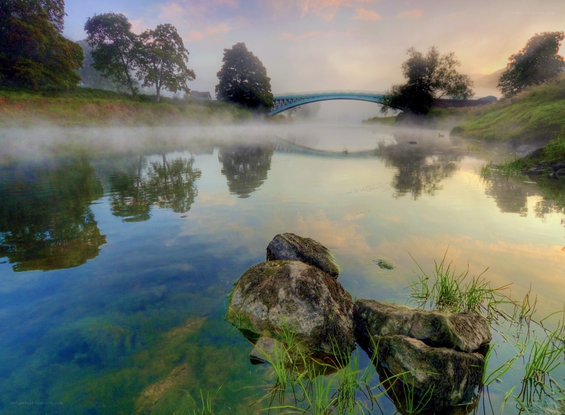 Misty river at dawn with bridge