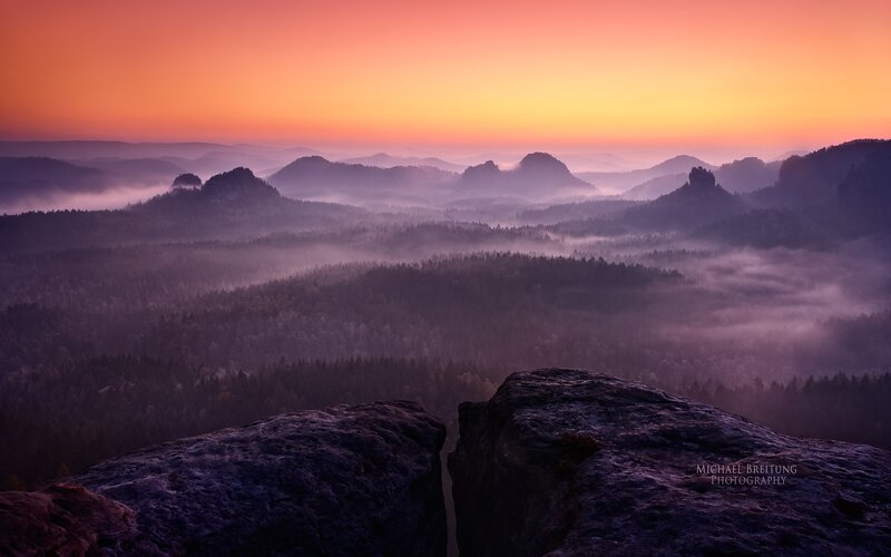 Misty sunrise over forested hills