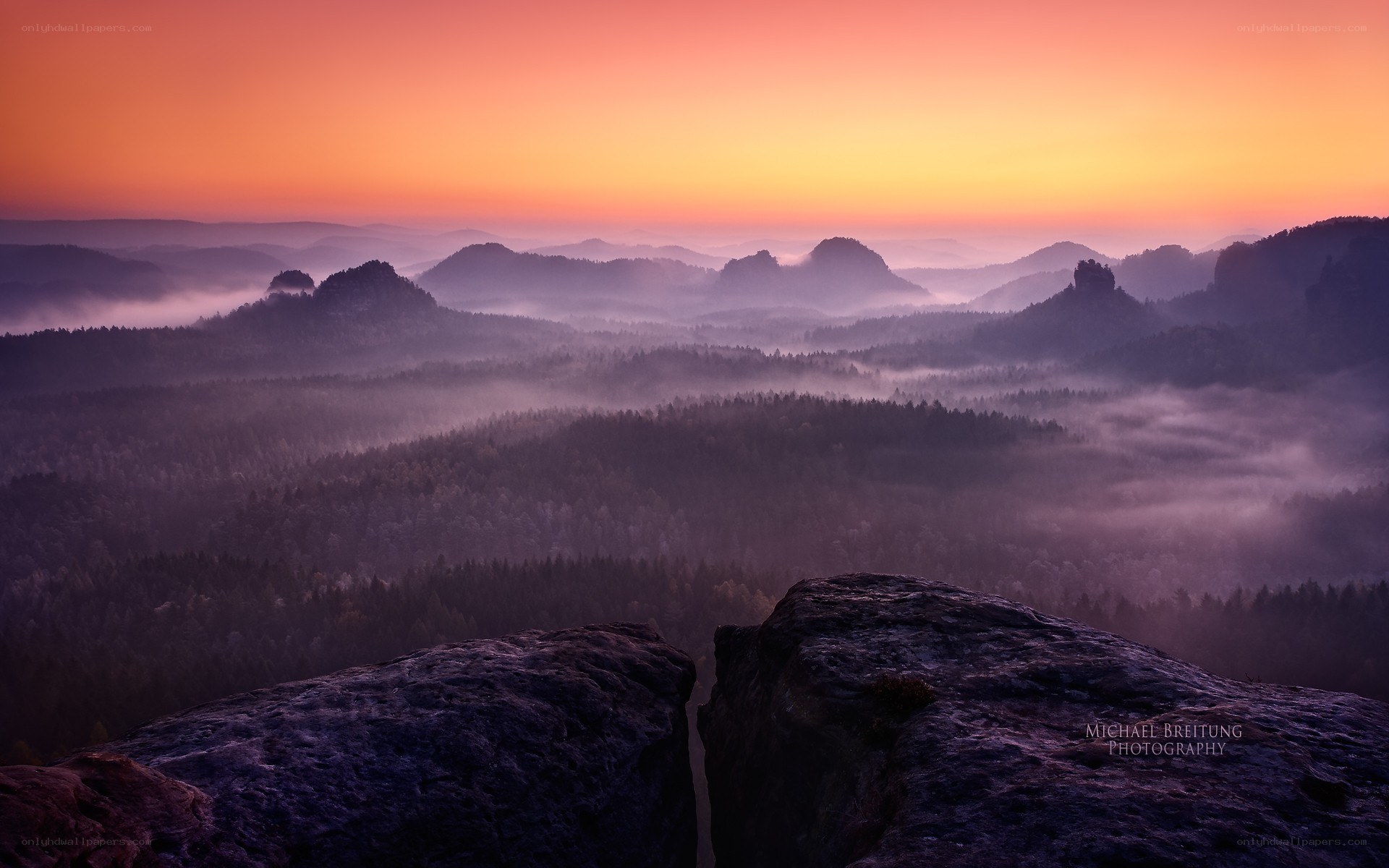 Misty sunrise over forested hills