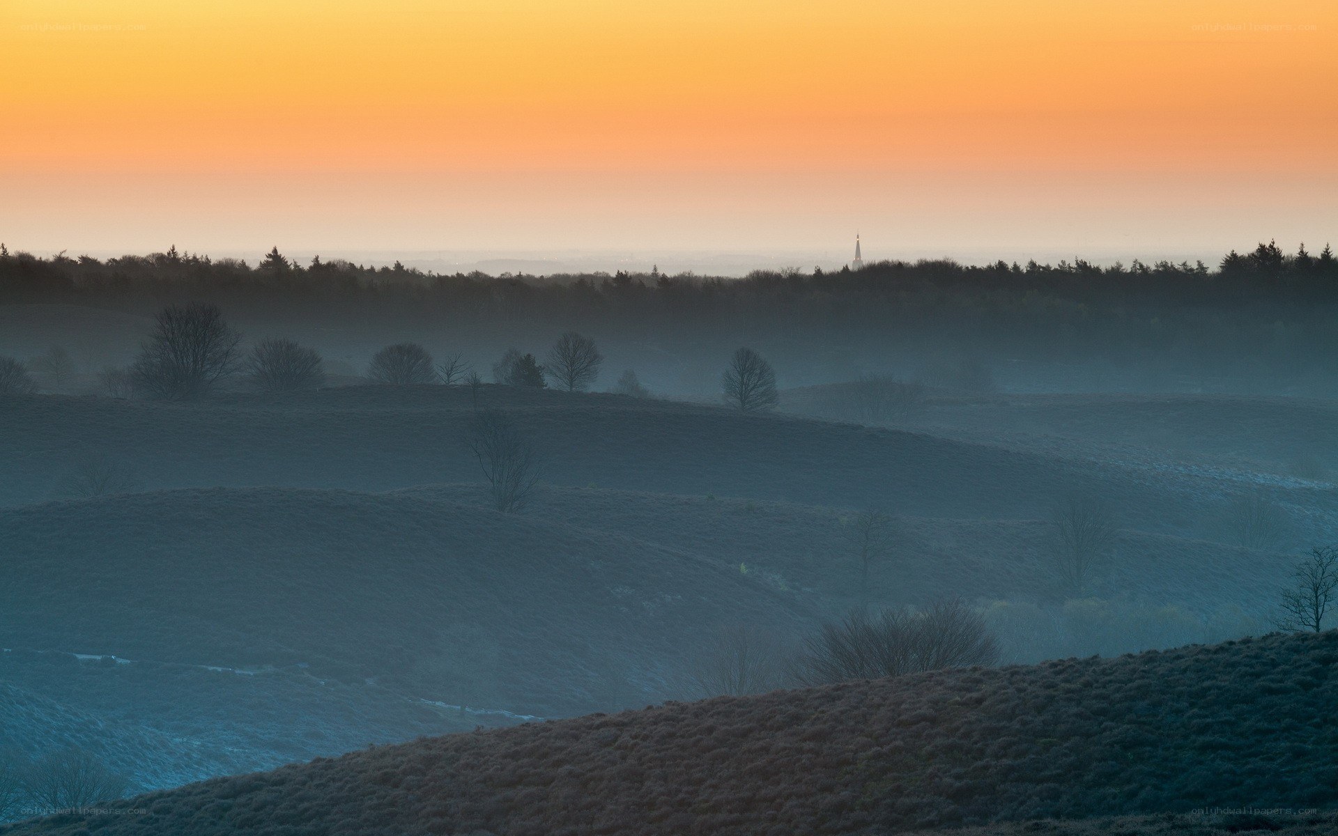 Misty sunrise over rolling hills