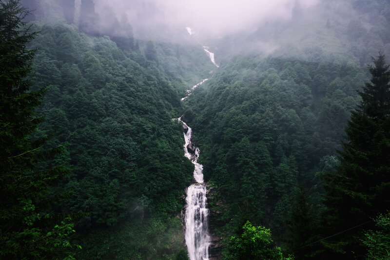 Misty waterfall in forest valley