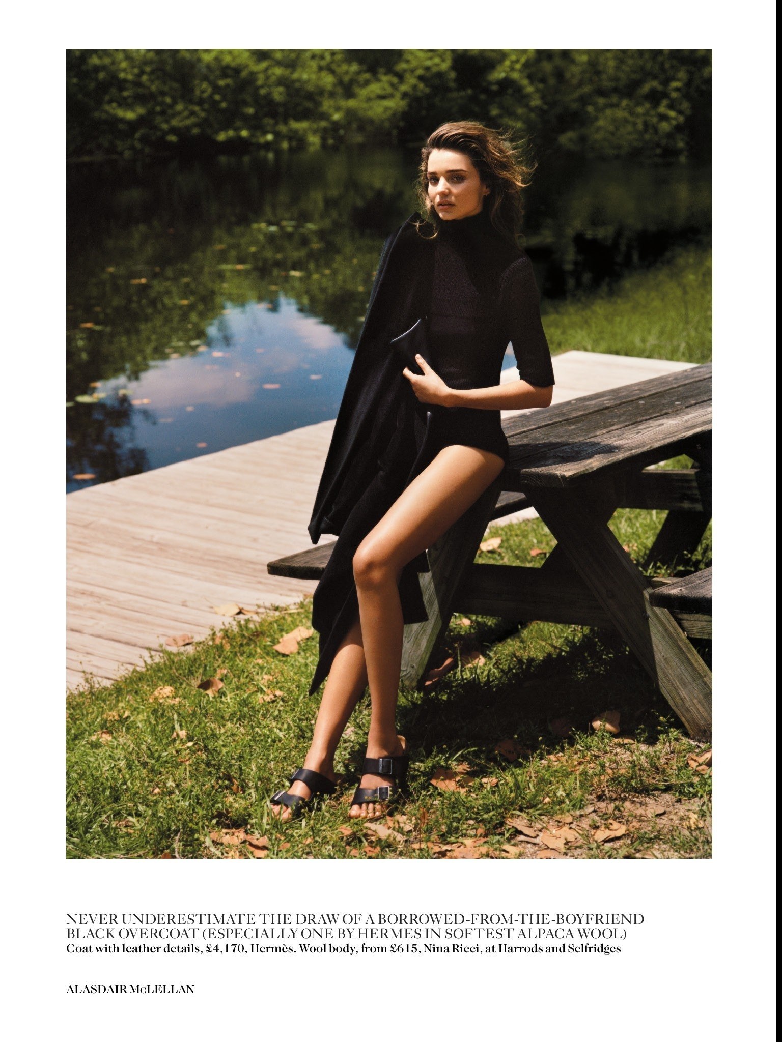 model by a lake in black outfit