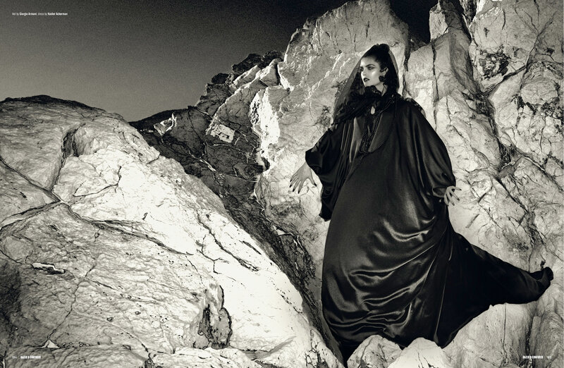 model in black robe on rocks