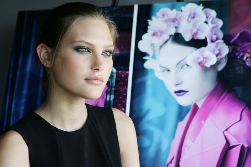model in front of fashion poster