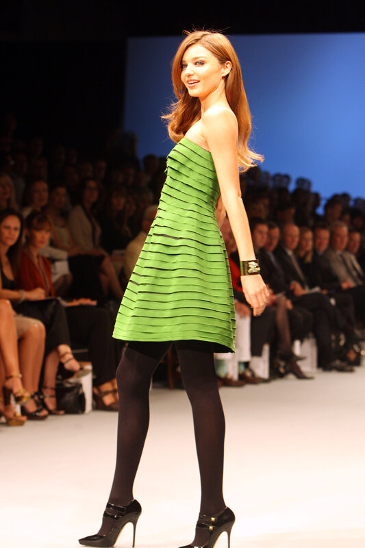 Model in green dress on runway