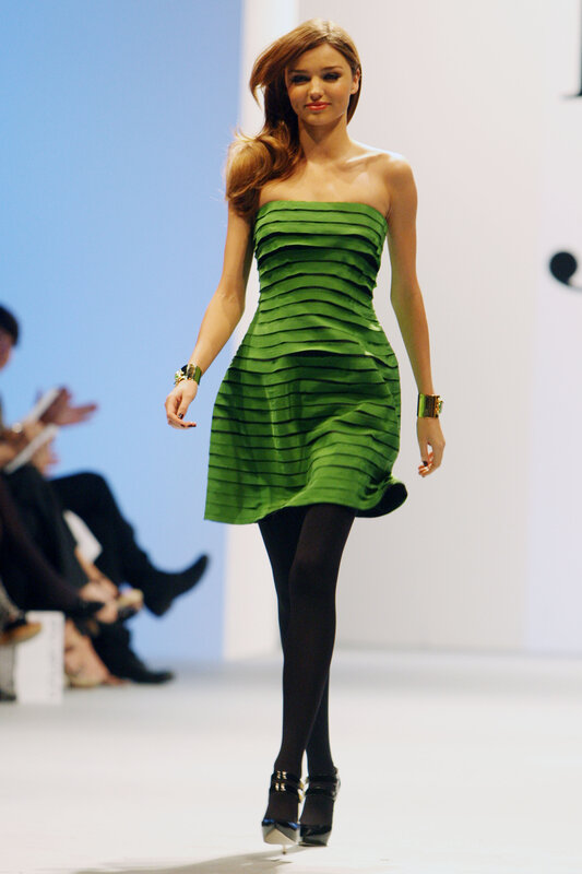 Model in green dress on runway