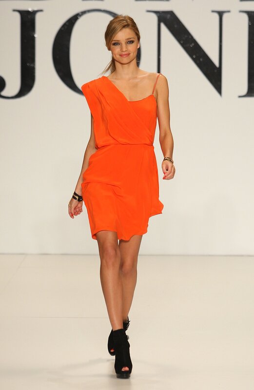 Model in orange dress on runway