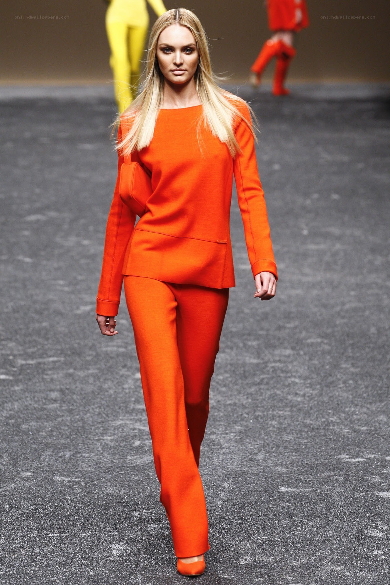 Model in orange suit on runway